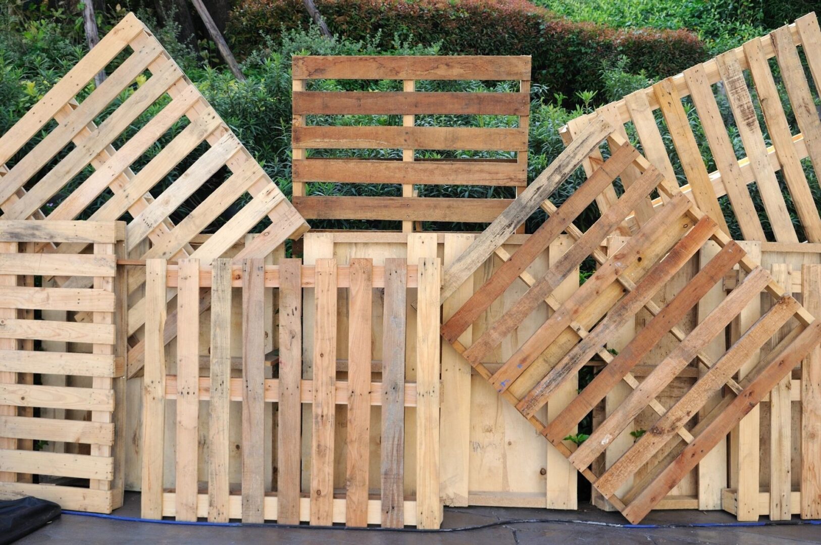 A pile of wooden pallets sitting on top of the ground.